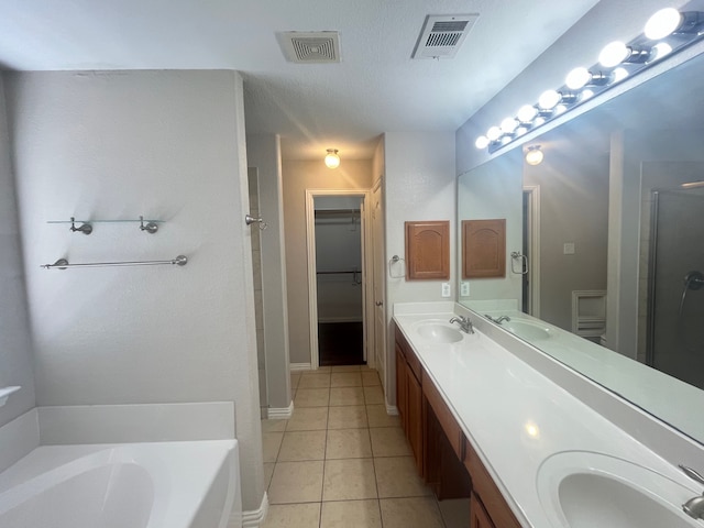 bathroom with a bath, visible vents, tile patterned floors, and a sink