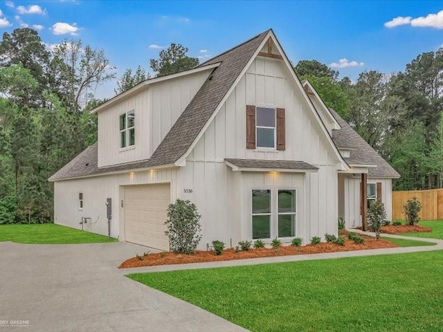 modern farmhouse style home featuring fence, concrete driveway, an attached garage, roof with shingles, and a front yard