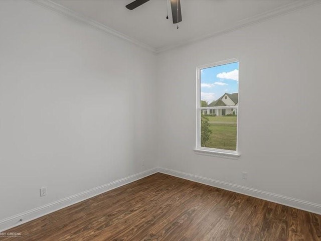 spare room with a ceiling fan, crown molding, baseboards, and dark wood-style flooring