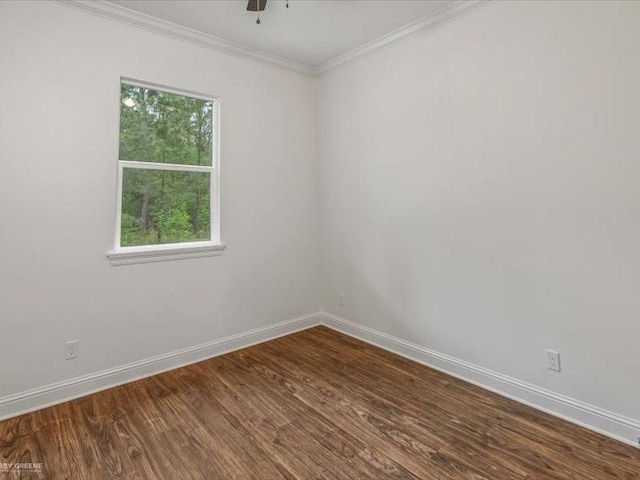 spare room featuring baseboards, ornamental molding, and dark wood-type flooring