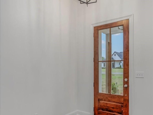 doorway to outside featuring baseboards