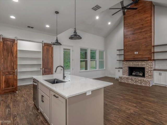 kitchen with a ceiling fan, a sink, open floor plan, dark wood-type flooring, and visible vents