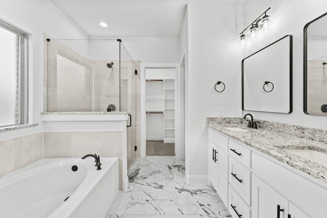 full bathroom featuring a sink, a stall shower, a spacious closet, marble finish floor, and a garden tub