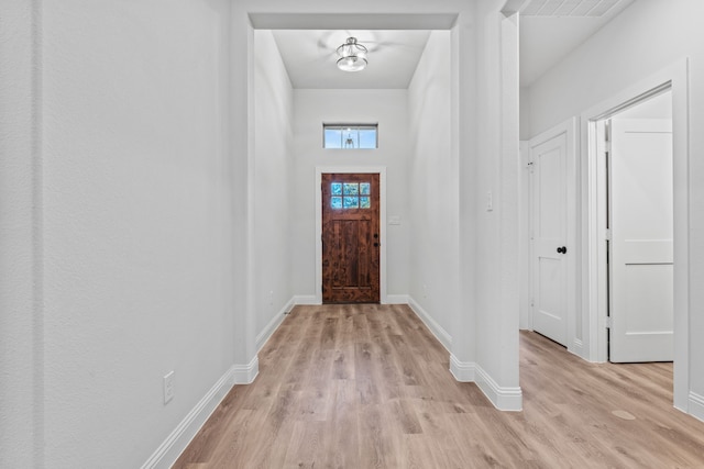 foyer entrance with light wood finished floors and baseboards