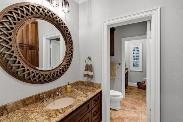 bathroom featuring toilet, vanity, and tile patterned floors