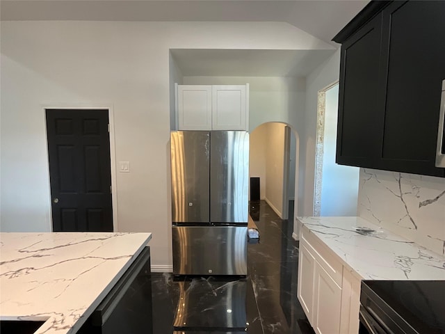 818 Rd 5607, Cleveland, TX 77327 - kitchen with arched walkways, backsplash, dark cabinets, light stone countertops, and freestanding refrigerator