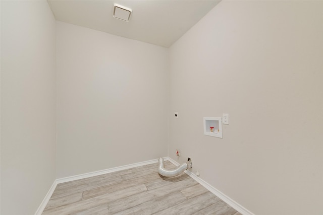 clothes washing area featuring hookup for a washing machine, hookup for an electric dryer, light wood-style floors, baseboards, and gas dryer hookup