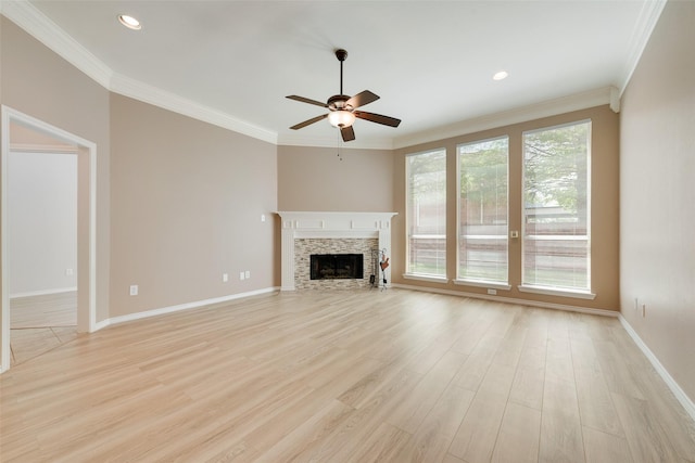 unfurnished living room featuring a fireplace, light wood finished floors, ornamental molding, and ceiling fan