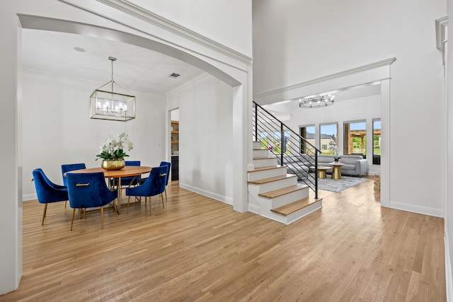 foyer featuring stairs, baseboards, wood finished floors, and a chandelier