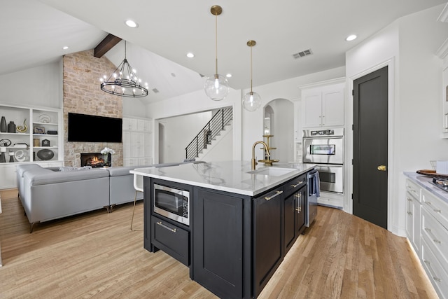 kitchen featuring white cabinets, visible vents, a sink, light wood-style floors, and appliances with stainless steel finishes