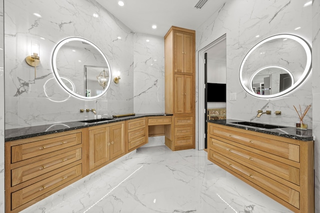 bathroom with marble finish floor, stone wall, vanity, and recessed lighting