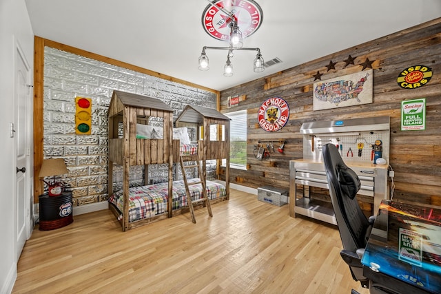 office space featuring wood walls, wood finished floors, visible vents, and baseboards