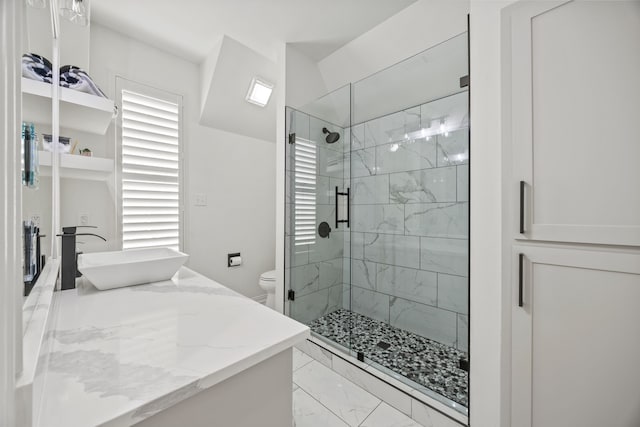 bathroom with a stall shower, vanity, marble finish floor, a healthy amount of sunlight, and toilet