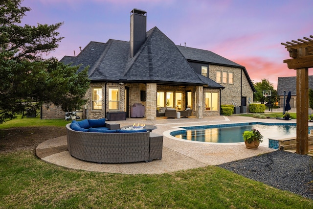 rear view of house with outdoor lounge area, a chimney, an outdoor pool, a patio, and roof with shingles