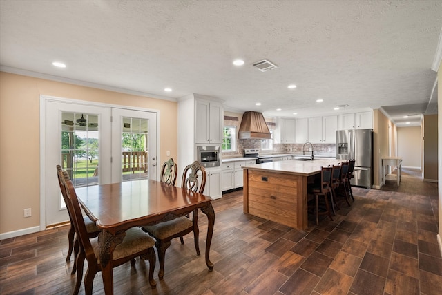 kitchen featuring a sink, visible vents, light countertops, appliances with stainless steel finishes, and premium range hood