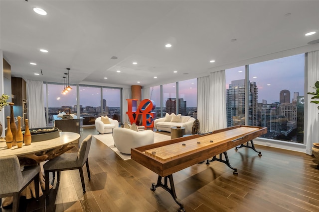 recreation room with a city view, wood finished floors, and floor to ceiling windows