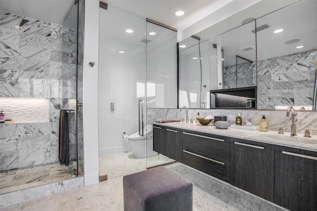 bathroom featuring marble finish floor, double vanity, visible vents, a marble finish shower, and a sink