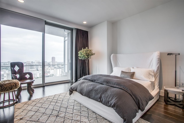 bedroom featuring a view of city, access to outside, wood finished floors, and recessed lighting