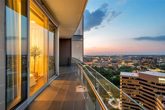 balcony at dusk featuring a view of city