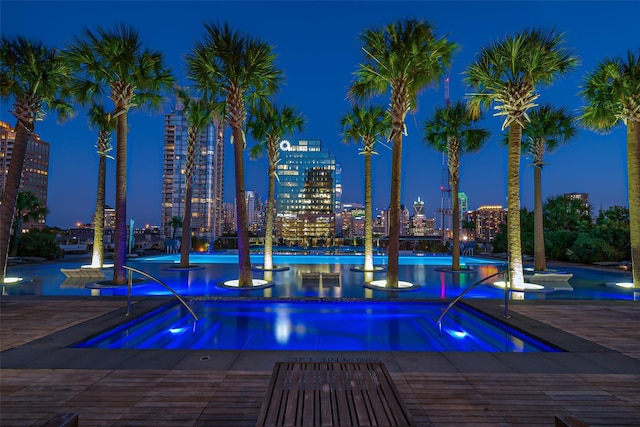 pool at twilight featuring a view of city lights