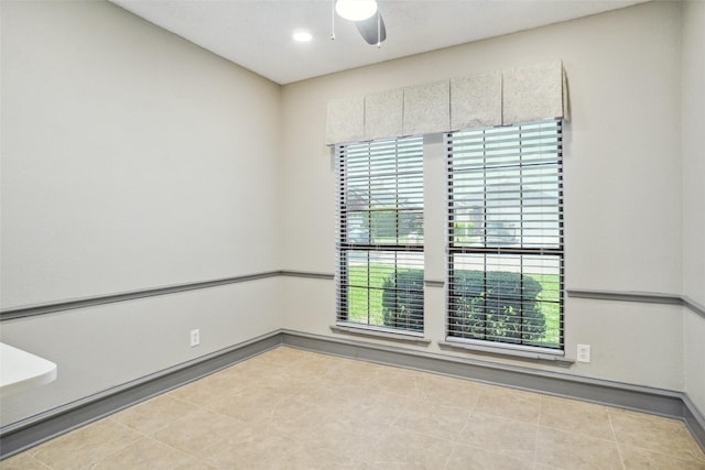 spare room featuring ceiling fan and baseboards