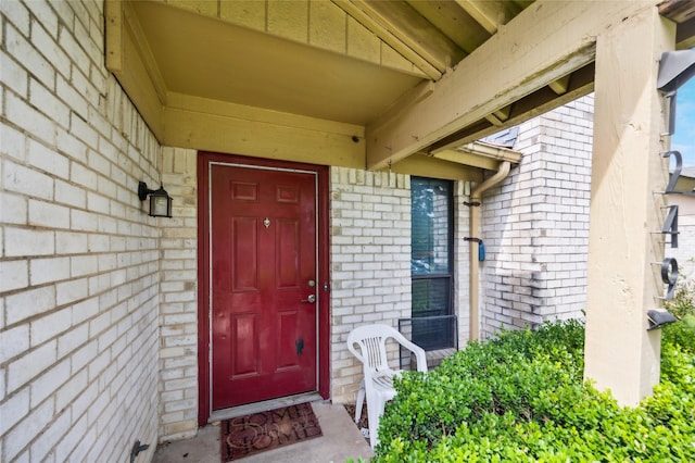 view of exterior entry with brick siding
