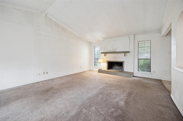 unfurnished living room with carpet flooring, a textured ceiling, lofted ceiling, and a fireplace