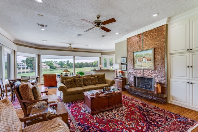 6001 Laurel Valley Ct, Fort Worth, TX 76132 - living room with a ceiling fan, crown molding, light wood finished floors, a textured ceiling, and a premium fireplace