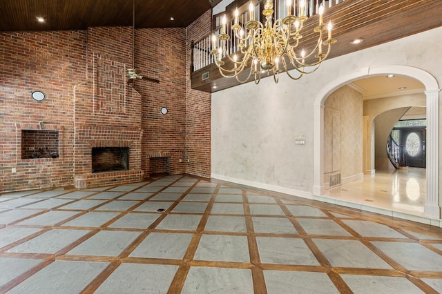 interior space with arched walkways, a brick fireplace, a high ceiling, and brick wall
