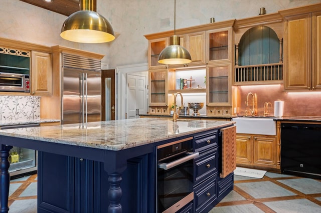 kitchen featuring decorative backsplash, an island with sink, stainless steel appliances, and hanging light fixtures