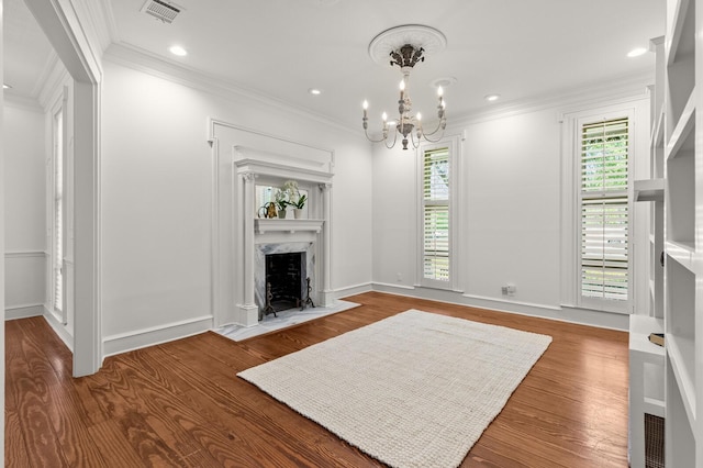 living room with a notable chandelier, crown molding, visible vents, and a fireplace