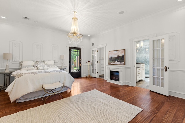 bedroom with wood finished floors, visible vents, a notable chandelier, and french doors