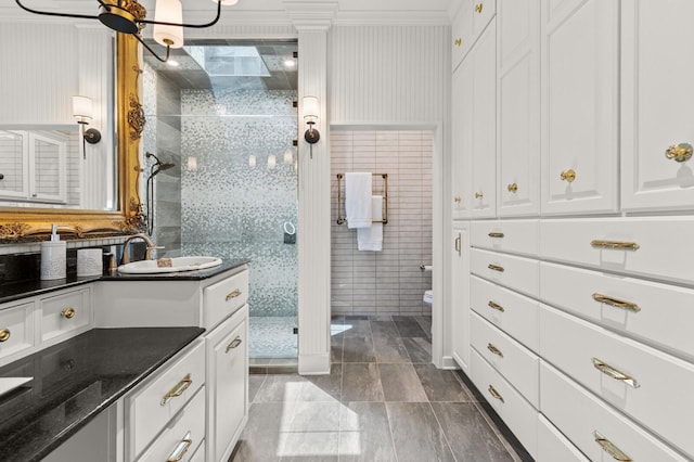 bathroom with a shower stall, vanity, tile walls, toilet, and tile patterned flooring