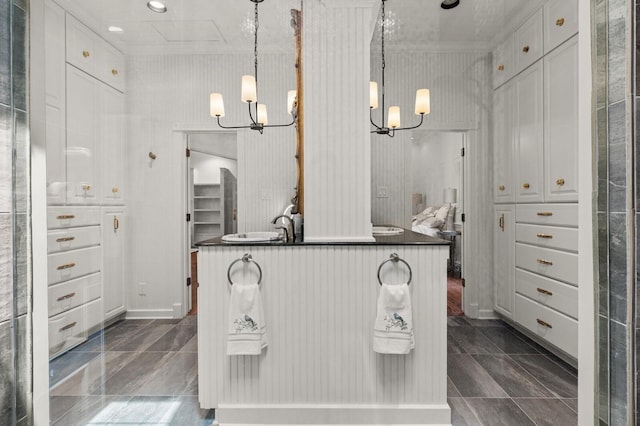 bathroom with crown molding and an inviting chandelier