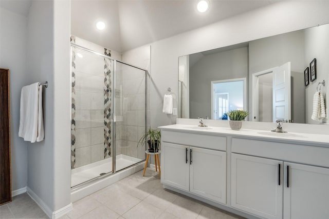 bathroom with tile patterned flooring, a sink, a shower stall, and double vanity