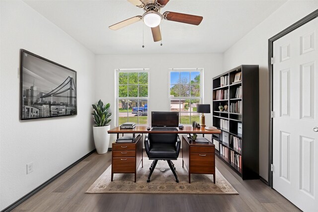 office space with baseboards, wood finished floors, and ceiling fan