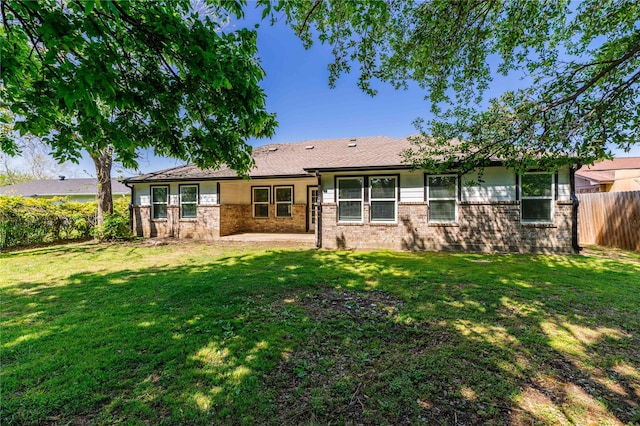 back of property featuring a patio area, fence, a yard, and brick siding