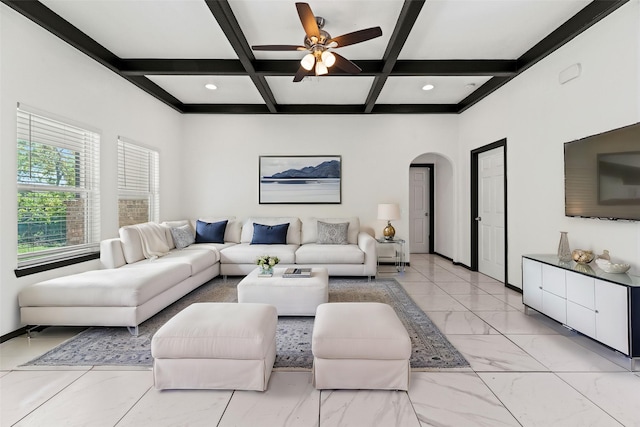 living room with arched walkways, a ceiling fan, coffered ceiling, and beamed ceiling