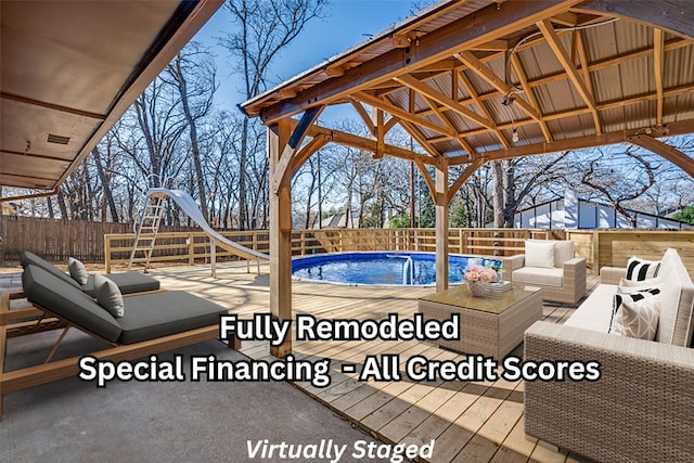 exterior space with a fenced backyard, a water slide, outdoor lounge area, and a fenced in pool