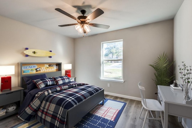 bedroom with wood finished floors, a ceiling fan, and baseboards