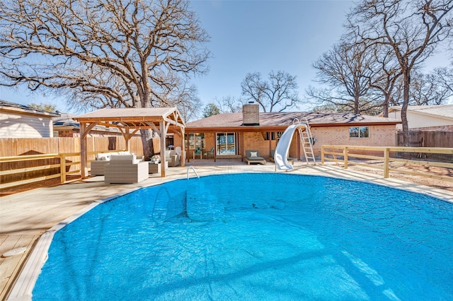 view of pool featuring a fenced in pool, a fenced backyard, a gazebo, a water slide, and a patio area