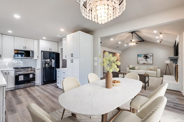 dining room with ceiling fan with notable chandelier, vaulted ceiling with beams, light wood finished floors, and recessed lighting