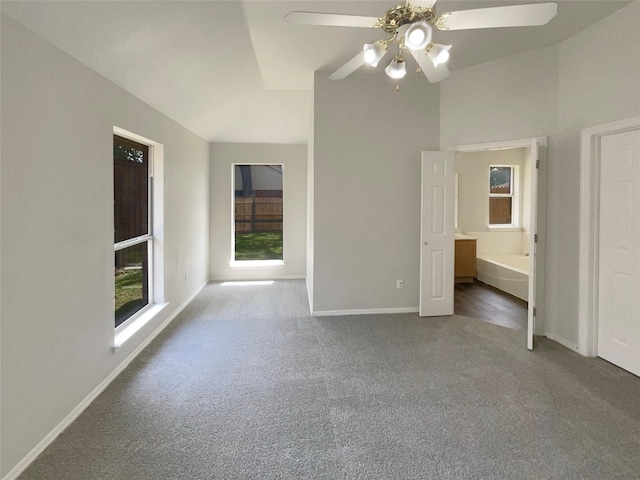 unfurnished bedroom with carpet, lofted ceiling, baseboards, and a ceiling fan