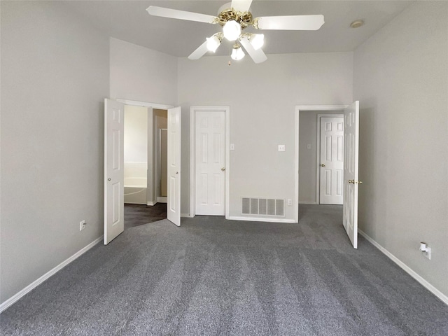 unfurnished bedroom with ceiling fan, baseboards, dark colored carpet, and visible vents