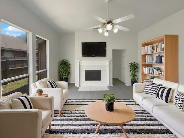 carpeted living area with a ceiling fan and a fireplace