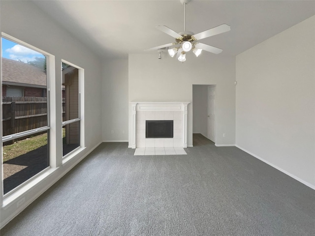 unfurnished living room featuring carpet, ceiling fan, baseboards, and a tiled fireplace
