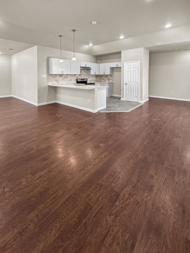 921 E Harvey Ave, Fort Worth, TX 76104 - unfurnished living room with dark wood finished floors, baseboards, recessed lighting, and a sink