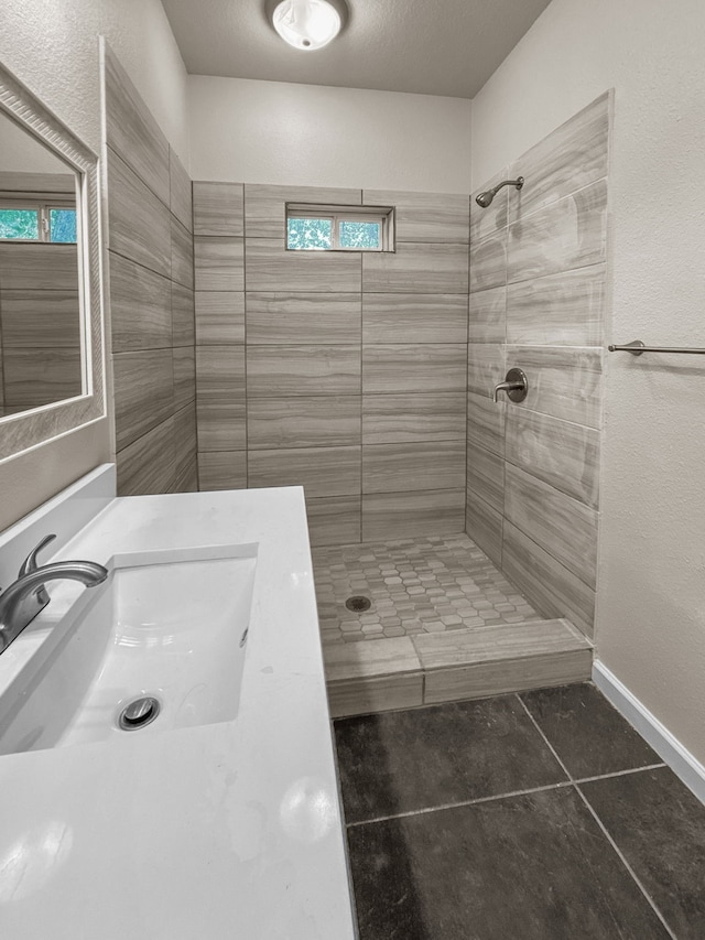 921 E Harvey Ave, Fort Worth, TX 76104 - full bathroom featuring tile patterned floors, a tile shower, vanity, and baseboards