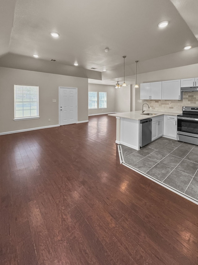 921 E Harvey Ave, Fort Worth, TX 76104 - kitchen with stainless steel appliances, a sink, open floor plan, light countertops, and dark wood finished floors