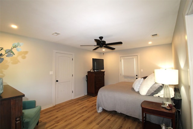 bedroom with a ceiling fan, wood finished floors, visible vents, and recessed lighting